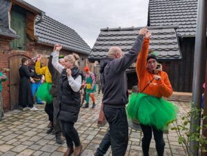 Gruppe von Menschen tanzt auf einem Hof