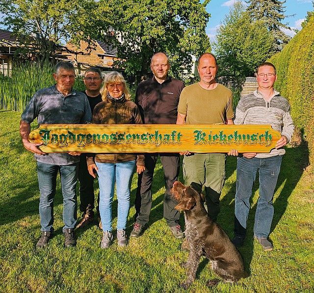 Gruppe von sechs Personen und ein Hund im Garten