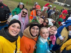 Eine Gruppe von Menschen in verschiedenen Kostümen, lächelnd.