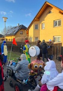 Menschen in Kostümen, Kinder im Rollstuhl