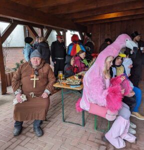 Ein Mann im Mittelalterlook neben einem Kind im rosa Kostüm