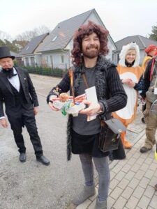 Ein Mann mit langen Haaren hält ein Tablett mit Süßigkeiten