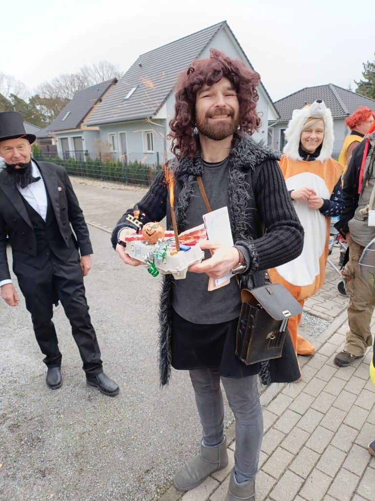 Ein Mann mit langen Haaren hält ein Tablett mit Süßigkeiten