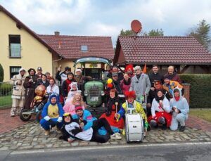 Eine Gruppe von Menschen in Kostümen vor einem Traktor