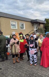 Gruppe von Leuten in Kostümen, darunter ein Zebra und andere bunte Outfits.