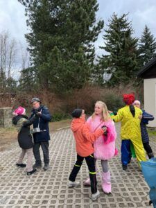 Gruppe von Menschen in bunten Kleidern wirft Wasserballons