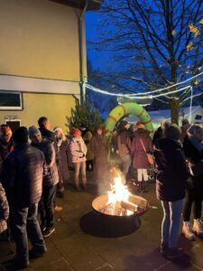Gruppe von Menschen um ein Lagerfeuer, Abendstimmung