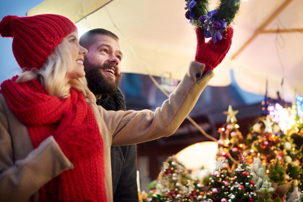 Ein Paar dekoriert einen Weihnachtskranz