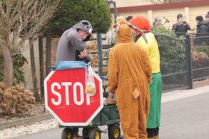 Männer in Kostümen mit einem Handwagen