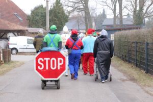 Gruppe von Leuten in Kostümen, STOP-Schild