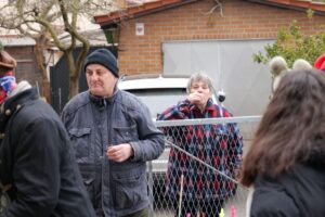 Mann und Frau stehen hinter einem Zaun